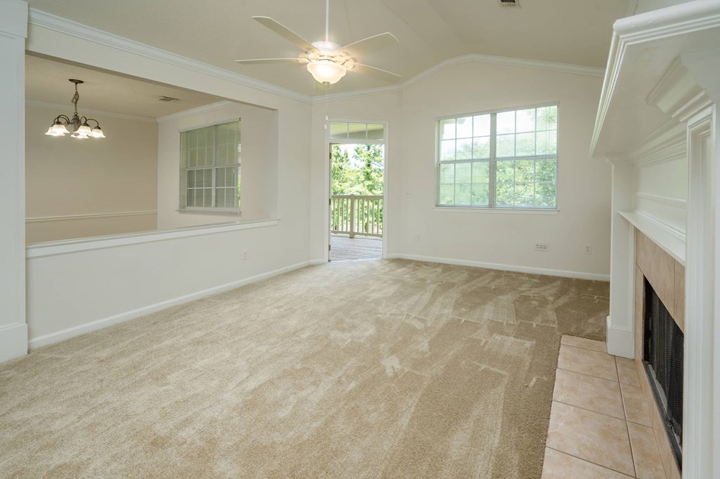 A large, empty room with a fireplace on the right side.