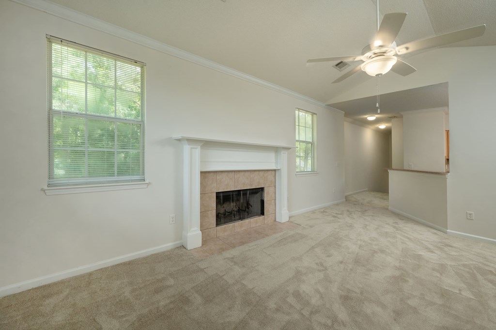A room with a fireplace and a ceiling fan.