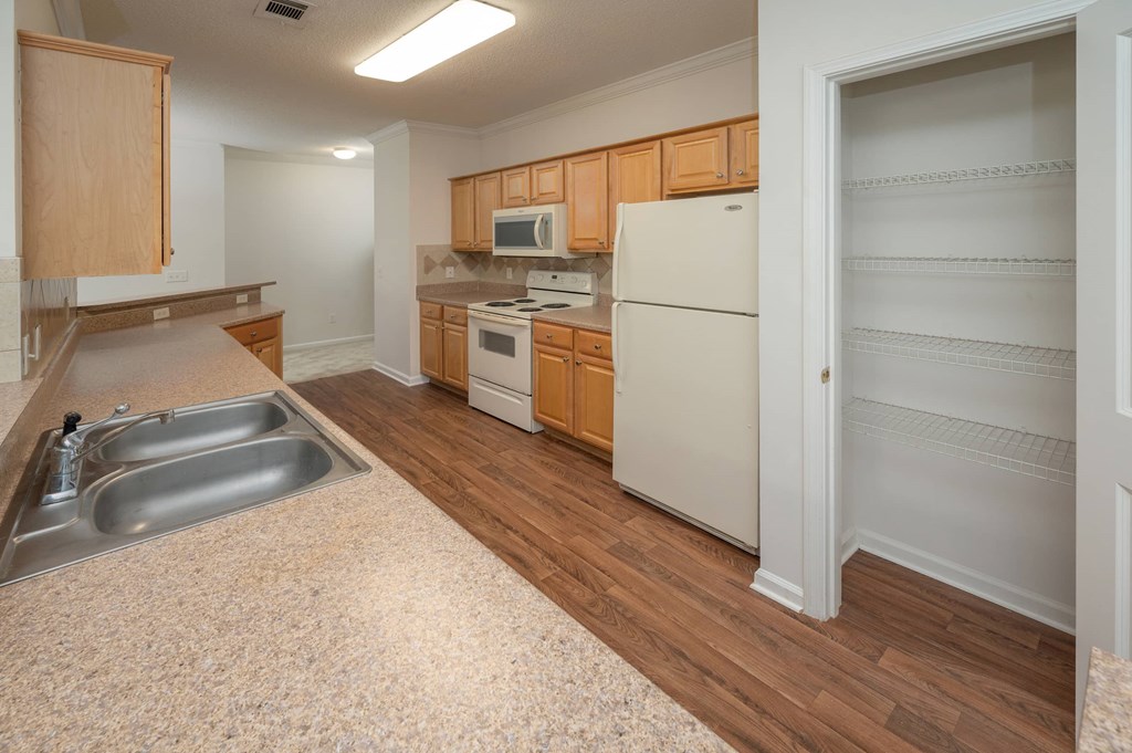 A kitchen with wooden cabinets and a white refrigerator.
