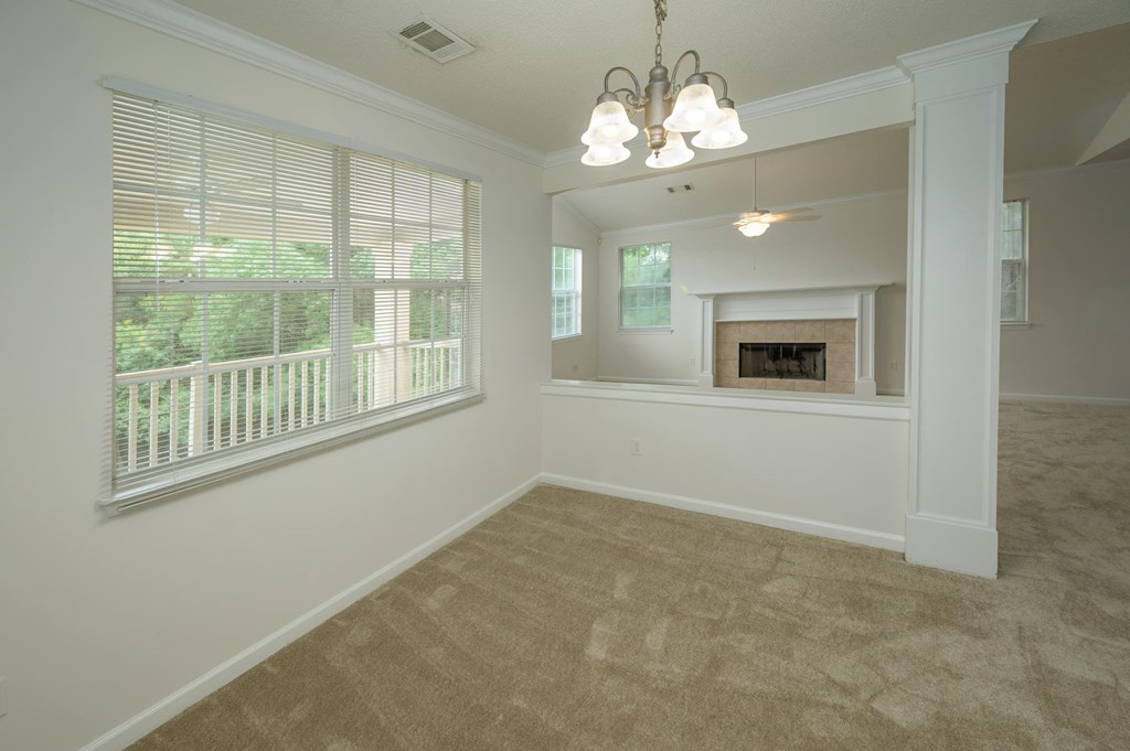 A well-lit room with a fireplace and a chandelier.