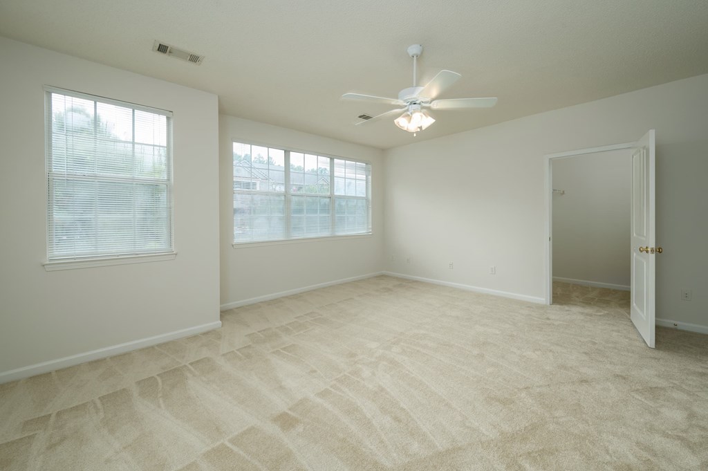 A room with a ceiling fan and a door.