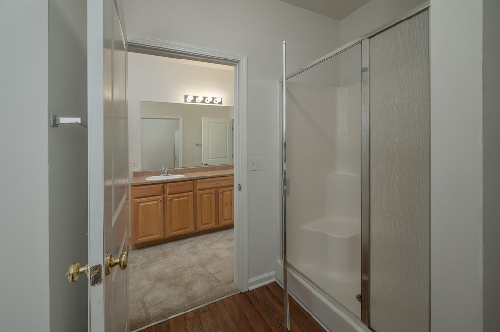A bathroom with a glass shower door and a sink.