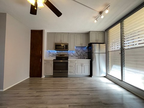 A kitchen with a refrigerator, oven, and microwave.
