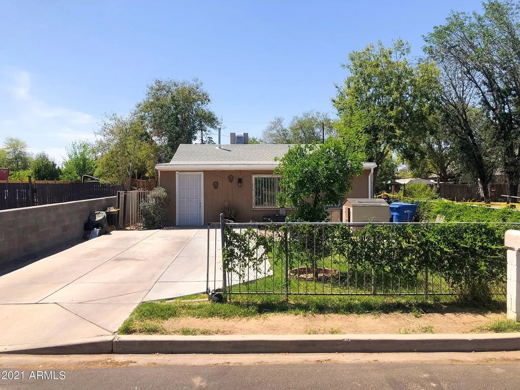 a small house with a driveway and a gate