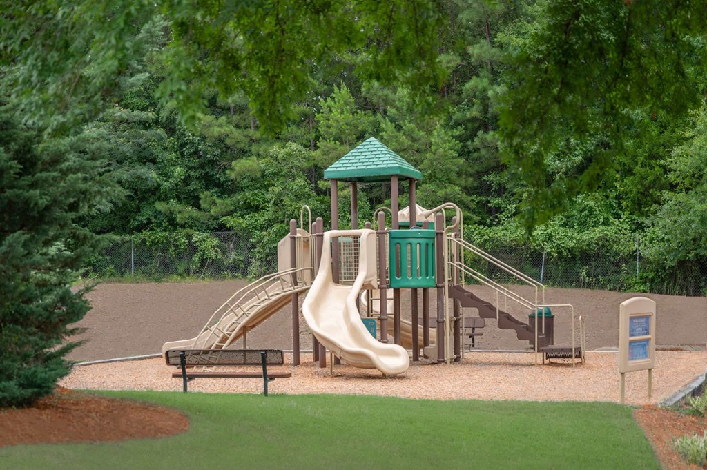 A playground with a green roofed structure and a slide.