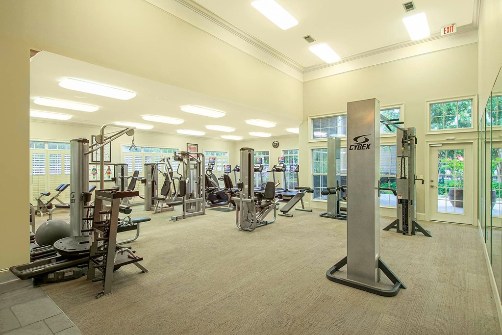 A gym with a variety of equipment including treadmills, weights, and exercise machines.