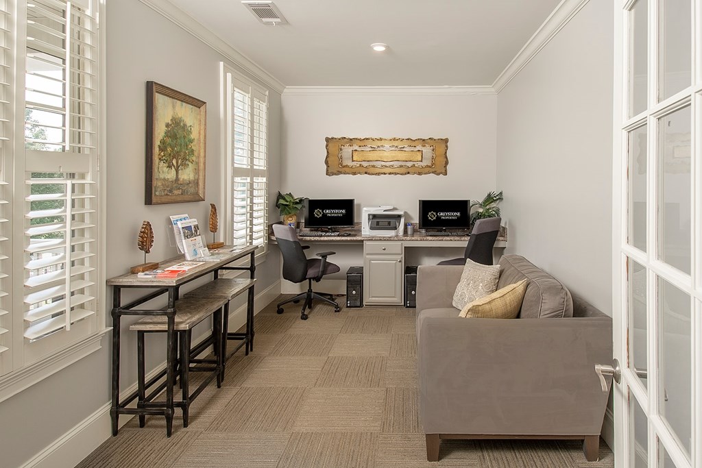 A room with a desk, chairs, and a couch.