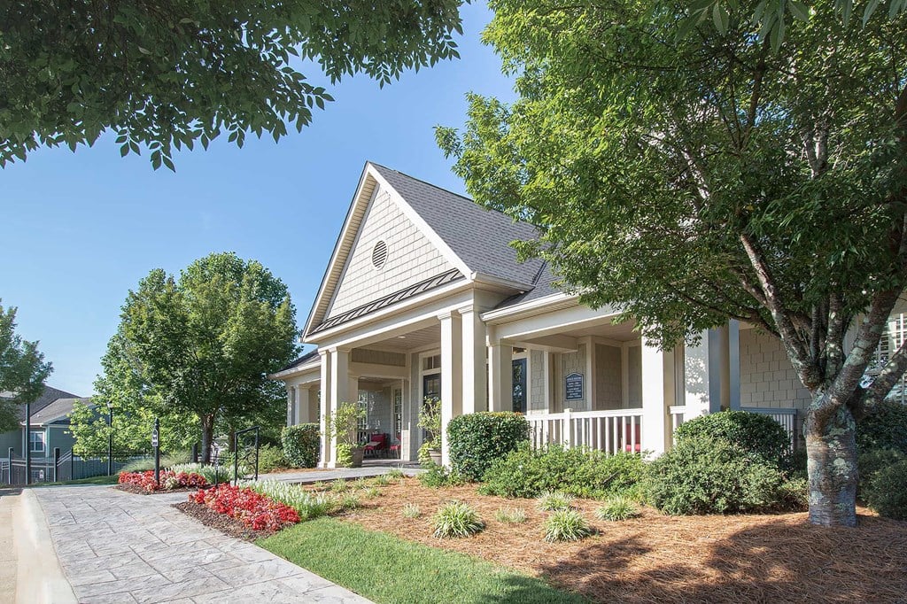 A house with a front porch and a tree in front.