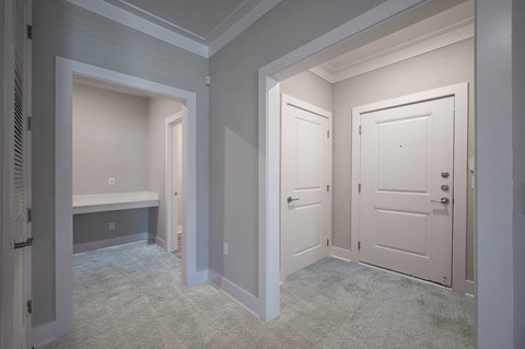 A hallway with two doors and a bench.