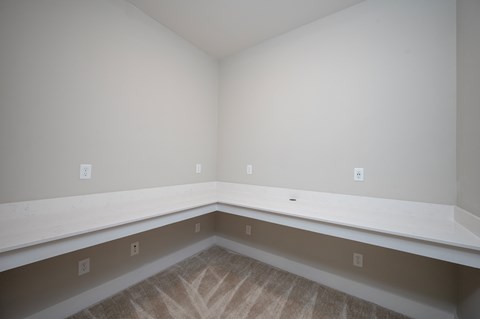 A room with a carpeted floor and baseboards.
