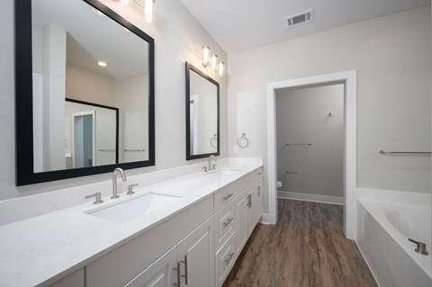 A bathroom with a white countertop and a large mirror above it.