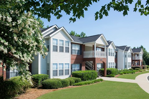 A row of townhouses with green bushes in front.