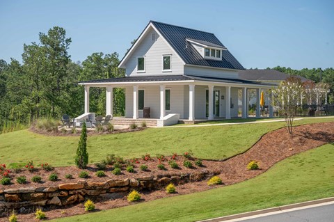 A white house with a black roof and a porch.