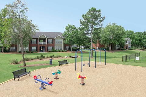 A playground with a slide, swings, and a seesaw.