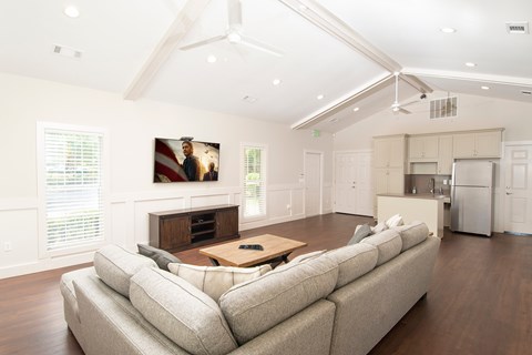 A living room with a large couch and a painting of two people on the wall.