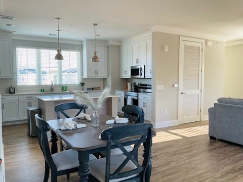 A kitchen with a dining table and chairs.