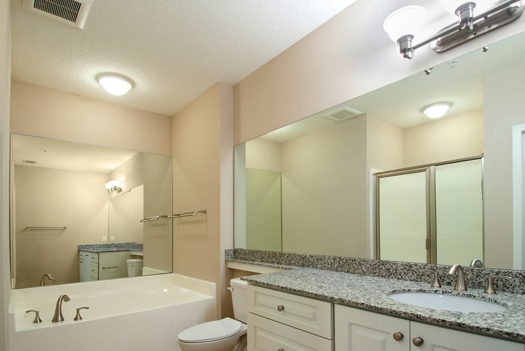 A bathroom with a white tub, sink, and toilet.