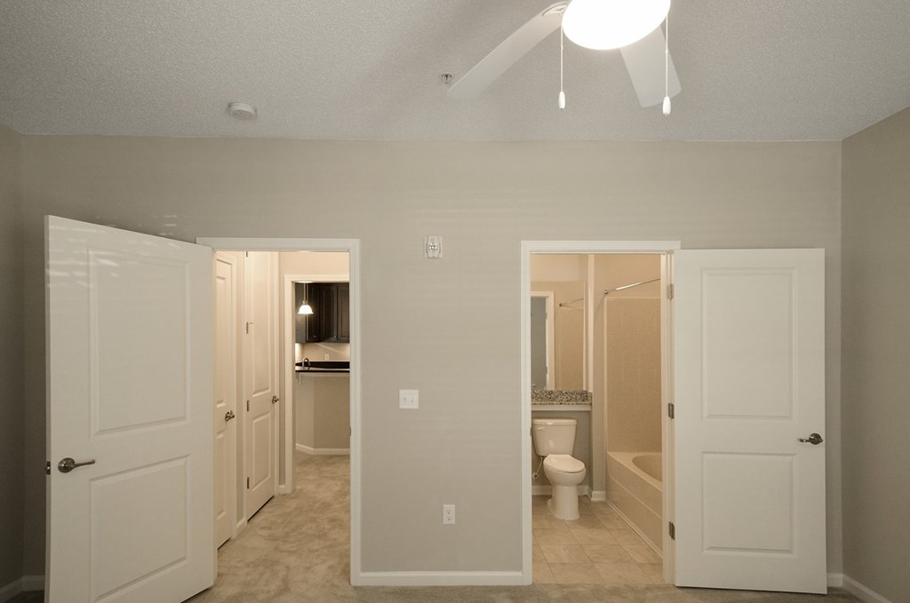 A white bathroom with a toilet, sink, and mirror.
