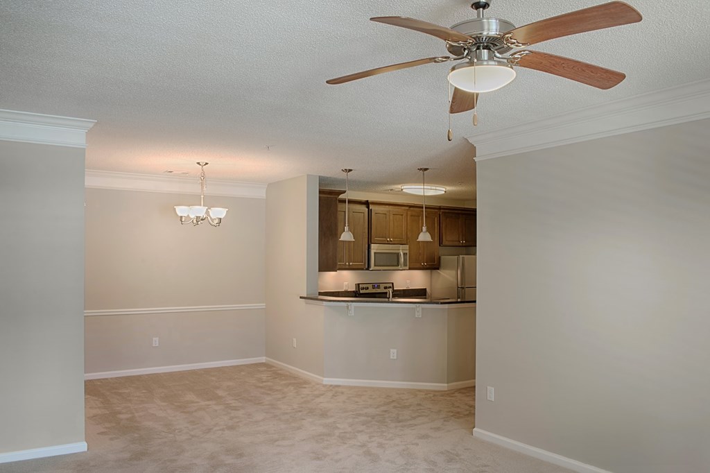A room with a ceiling fan and a chandelier.
