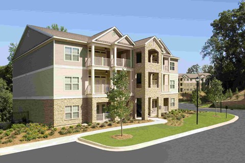 A modern two-story apartment building with a balcony on the second floor.