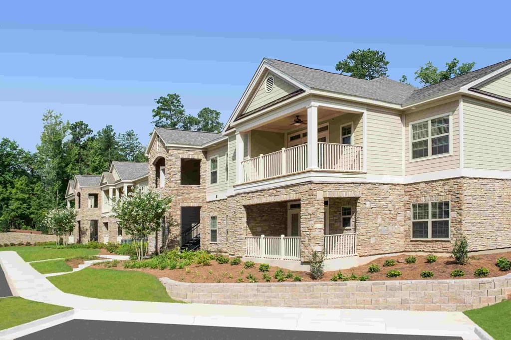A large, two-story residential building with a balcony on the upper floor.