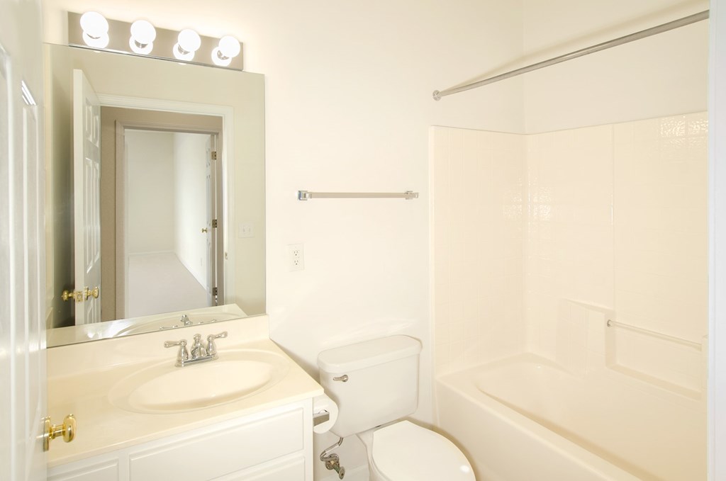 A white bathroom with a sink, toilet, and bathtub.