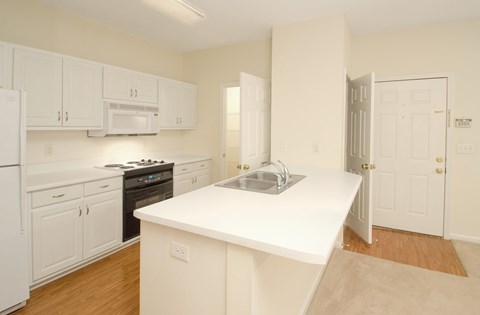 A kitchen with white cabinets and appliances.