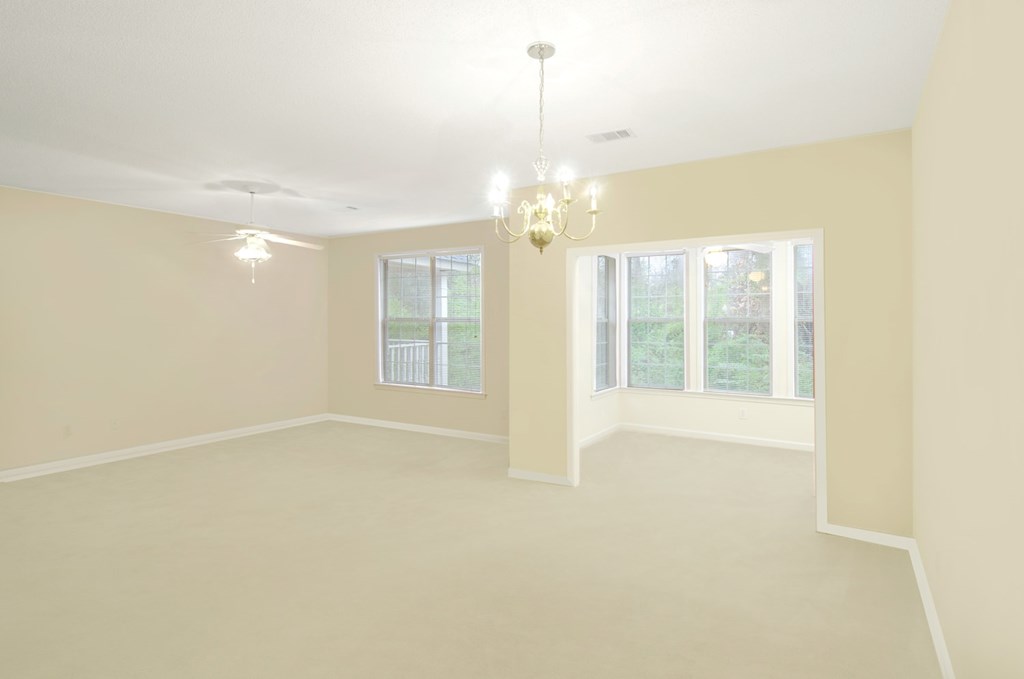 A room with a chandelier and two windows.