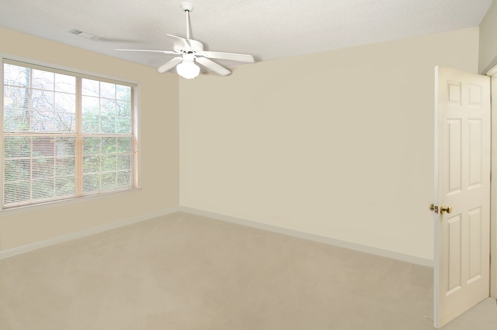 A room with a ceiling fan and a door.