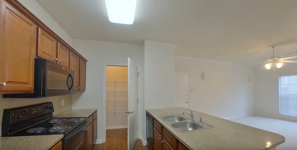 A kitchen with brown cabinets and a black stove top oven.