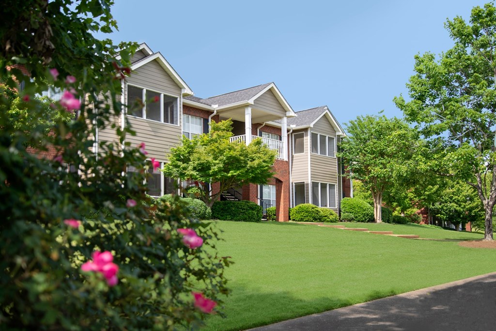 A house with a well-manicured lawn and a clear blue sky.
