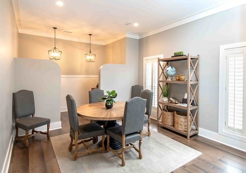 A dining room with a round table and chairs.
