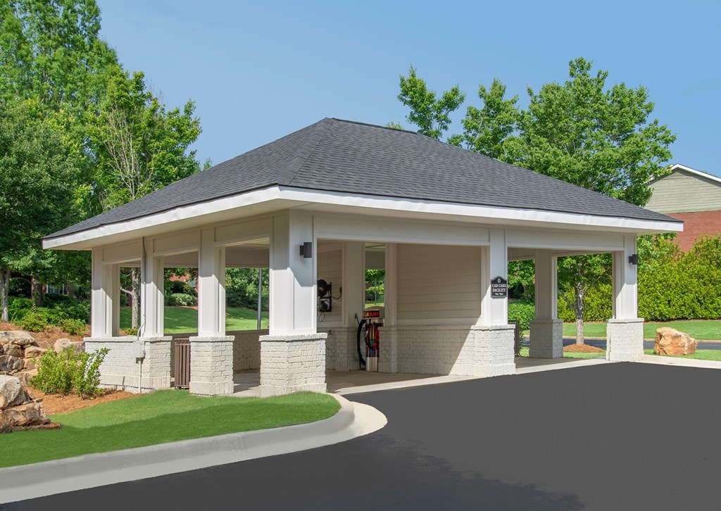 A small white building with a black roof and a covered walkway.