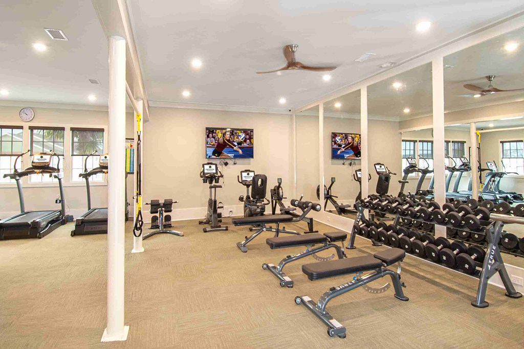 A spacious gym with a variety of equipment including treadmills, weights, and exercise machines.