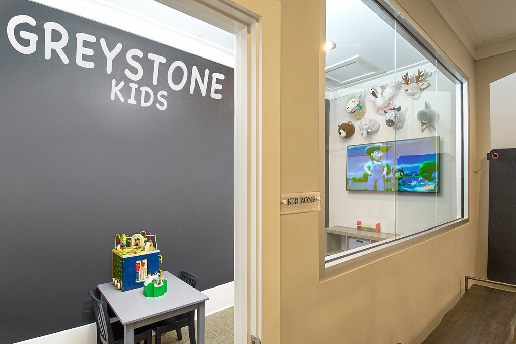A room with a sign that says "Greystone Kids" and a table with a toy on it.
