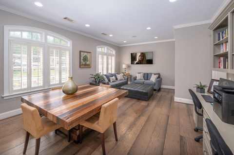 A modern dining room with a wooden table and chairs.