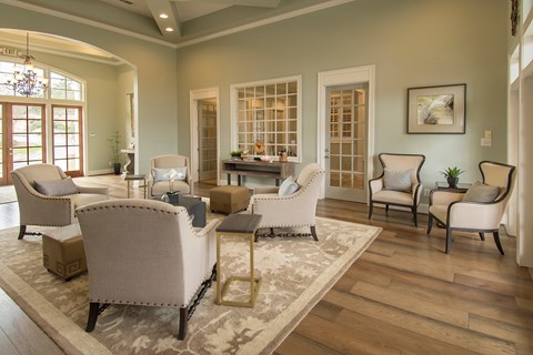 A living room with a rug and chairs.