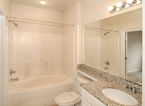 A white bathroom with a toilet, sink, and bathtub.