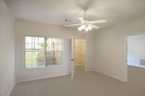 A room with a ceiling fan and a window.