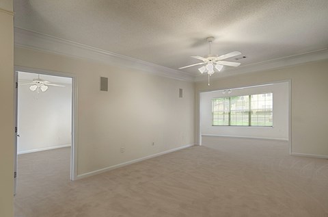 A room with a ceiling fan and a window.