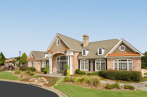 A large house with a grey roof and a brick chimney.