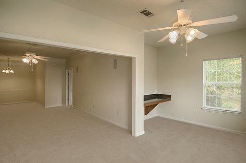 A room with a ceiling fan and a window with blinds.