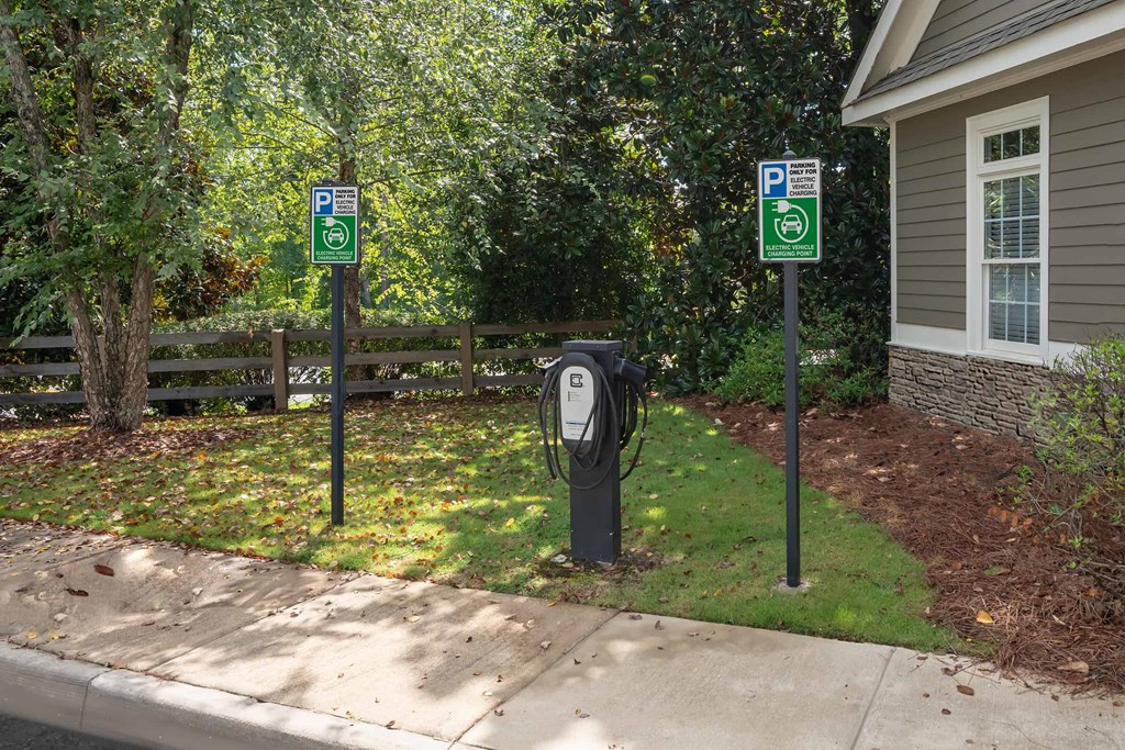 Two parking signs are on posts next to a parking meter.
