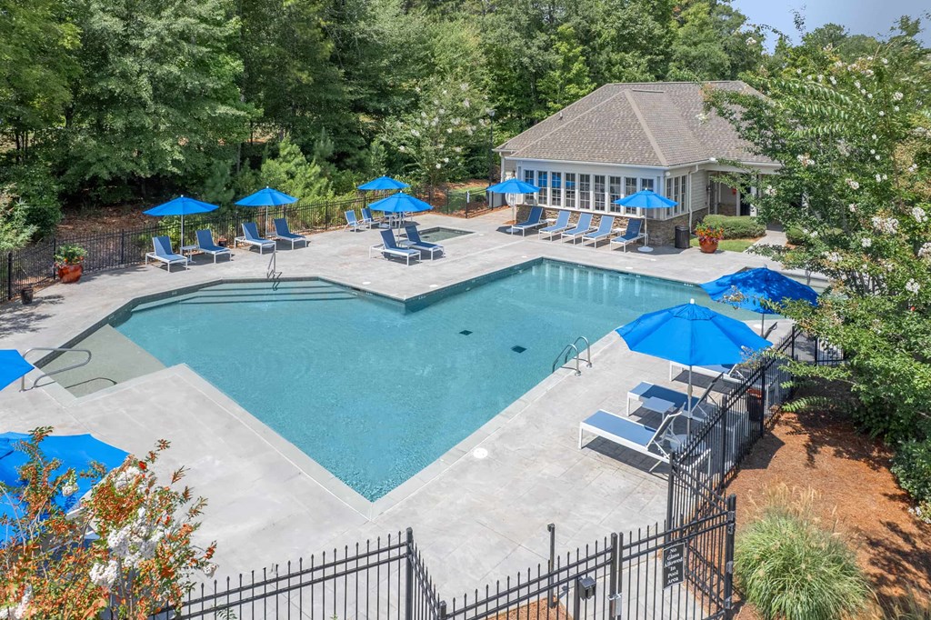 A pool surrounded by trees and a gazebo.
