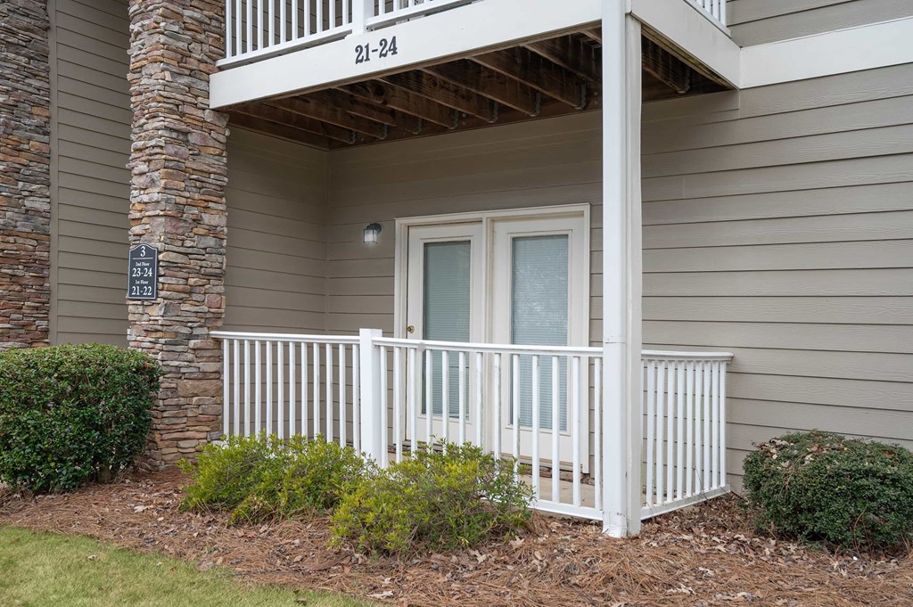 A balcony with a white railing and a glass door.