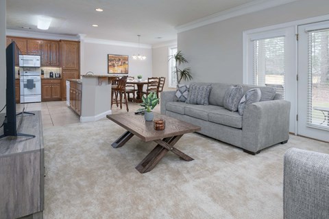 A modern living room with a grey couch and a wooden coffee table.