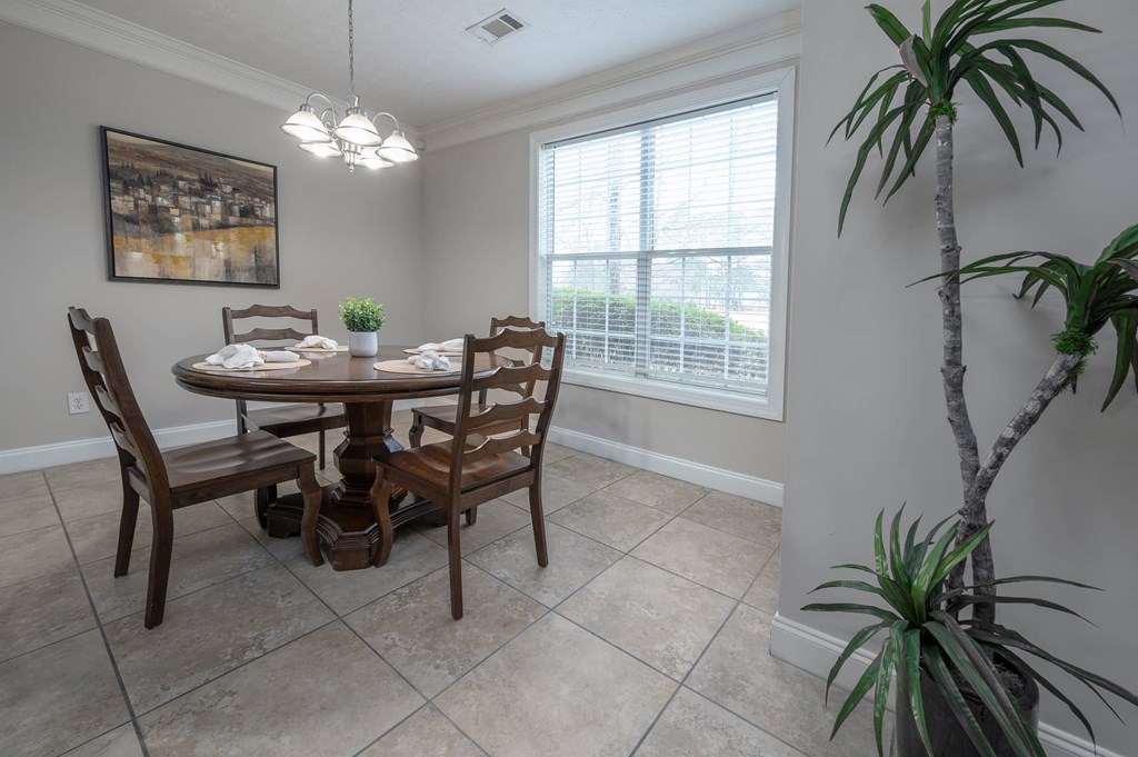 A dining room with a table and chairs.