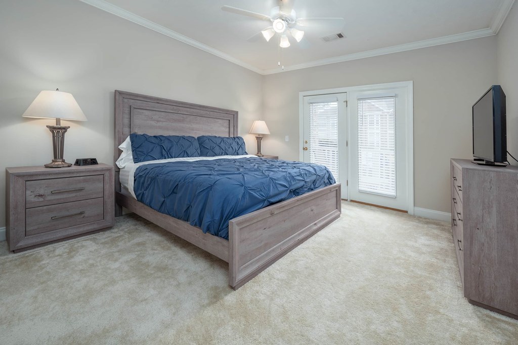 A bedroom with a bed, nightstand, and television.