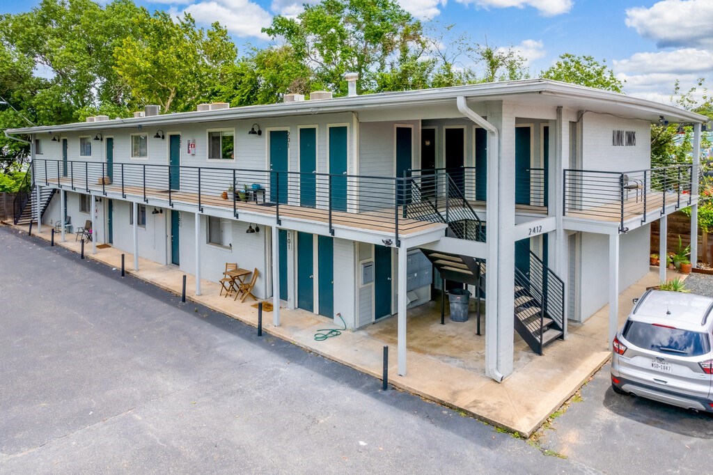 a building with a balcony and a parking lot