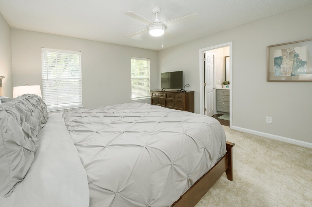 A bedroom with a large bed and a television in the corner.